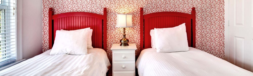 Two twin beds with red headboards.