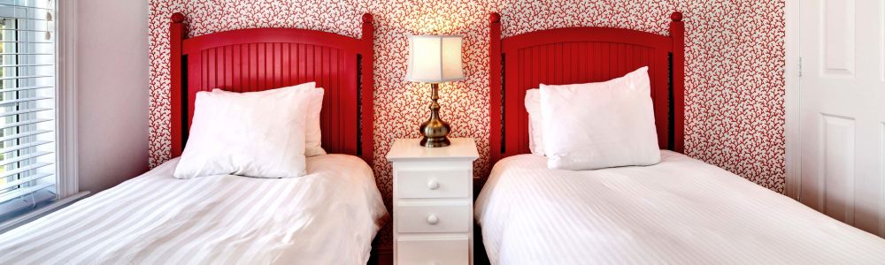 Two twin beds with red headboards.