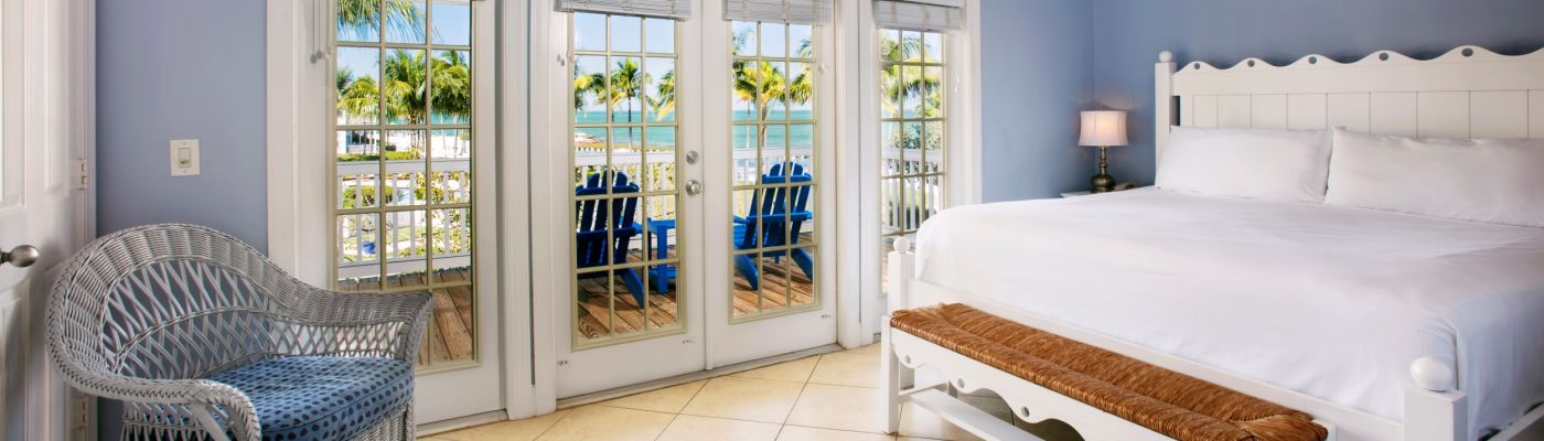 A guest room with a glass panel doors that open to a private porch.